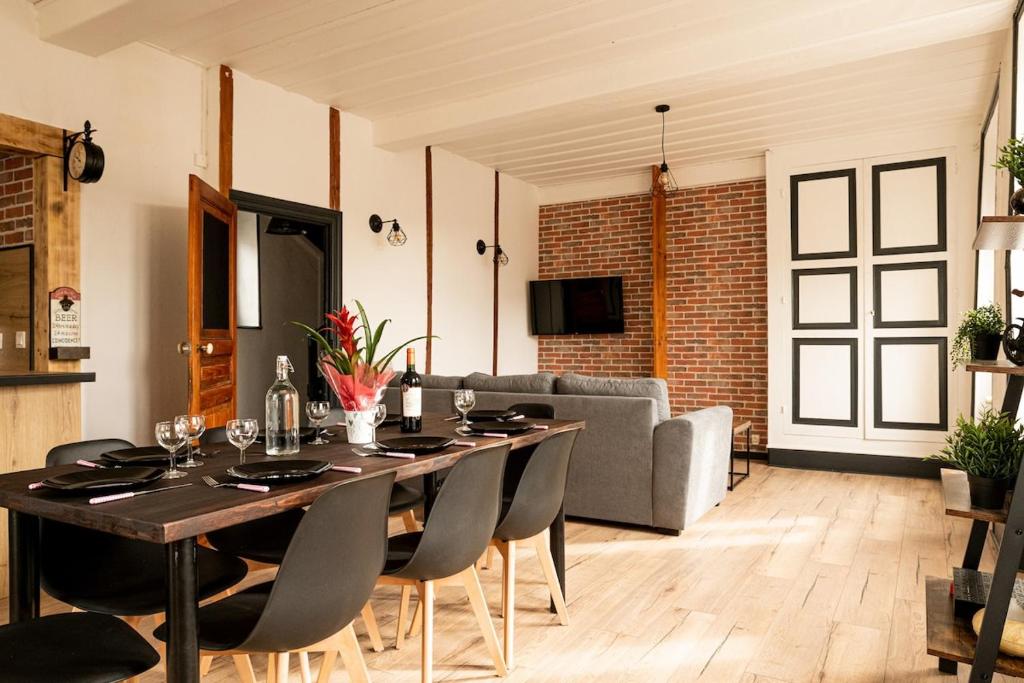 a dining room with a table and a couch at Bienvenue chez vous ! in LʼEstrade
