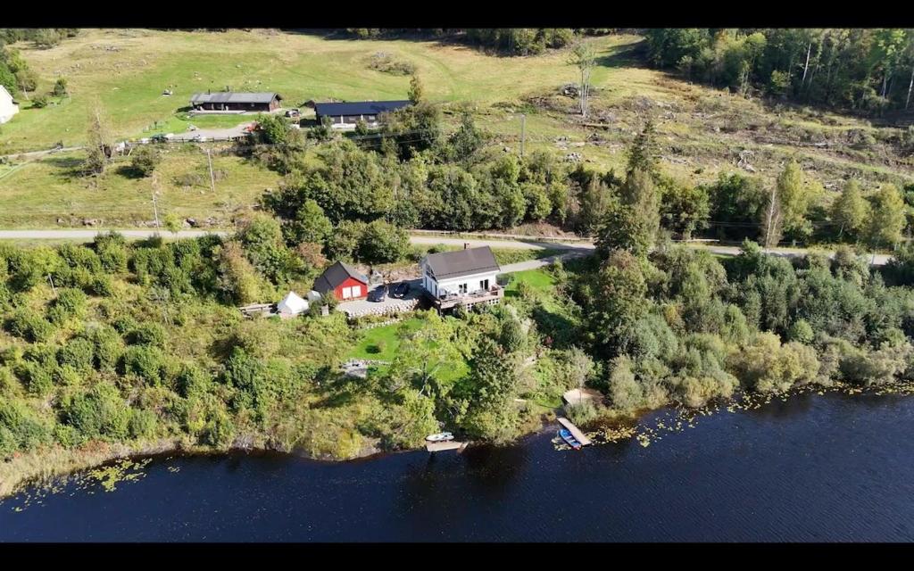 an aerial view of a house on an island in the water at Idyllic Lake House - 4 rooms & 2 Glamping Tents Available in Porsgrunn