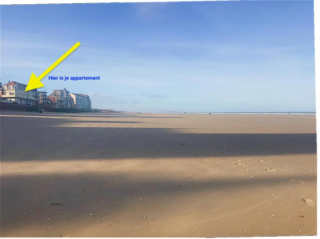 - une vue sur une plage avec une flèche jaune dans l'établissement unobstructed beachfront view apartment, à Bray-Dunes