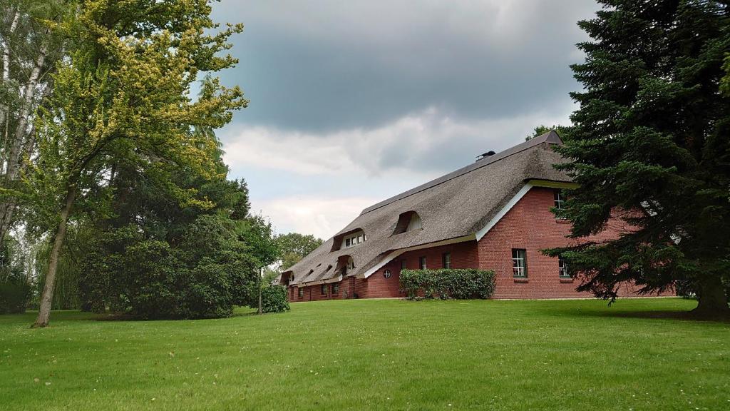a red brick building with a gambrel roof at De Leev - Landhaus Lübbertsfehn in Ihlow