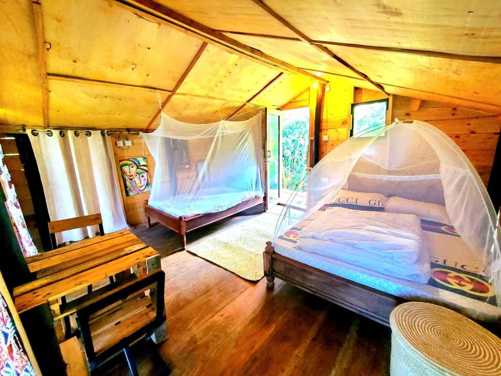 een slaapkamer met een bed met een klamboe bij Aroma Home - Eco-Cabins on a Coffee Farm in Arusha