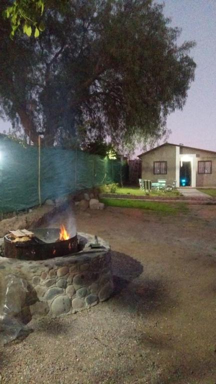 a fire pit in a yard next to a house at Cabaña la Morocha in Ciudad Lujan de Cuyo
