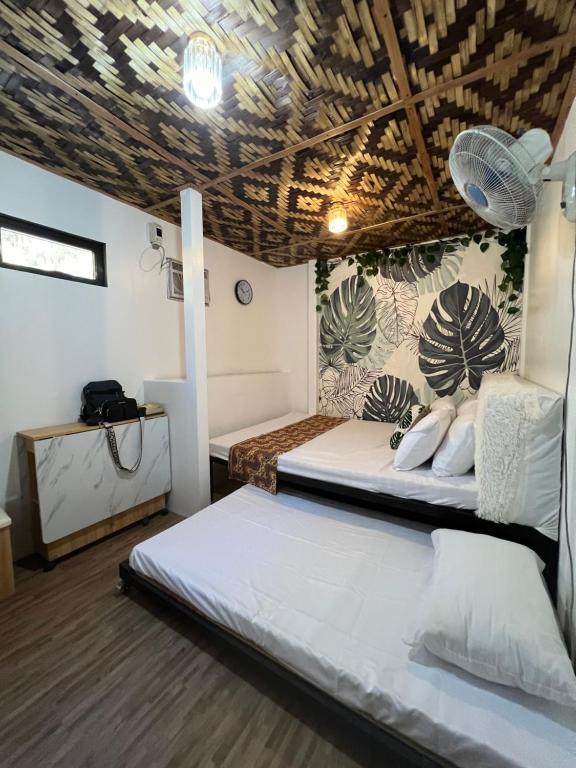 a bedroom with two beds and a wooden ceiling at Happy hut retreat of Zambales in Zambales