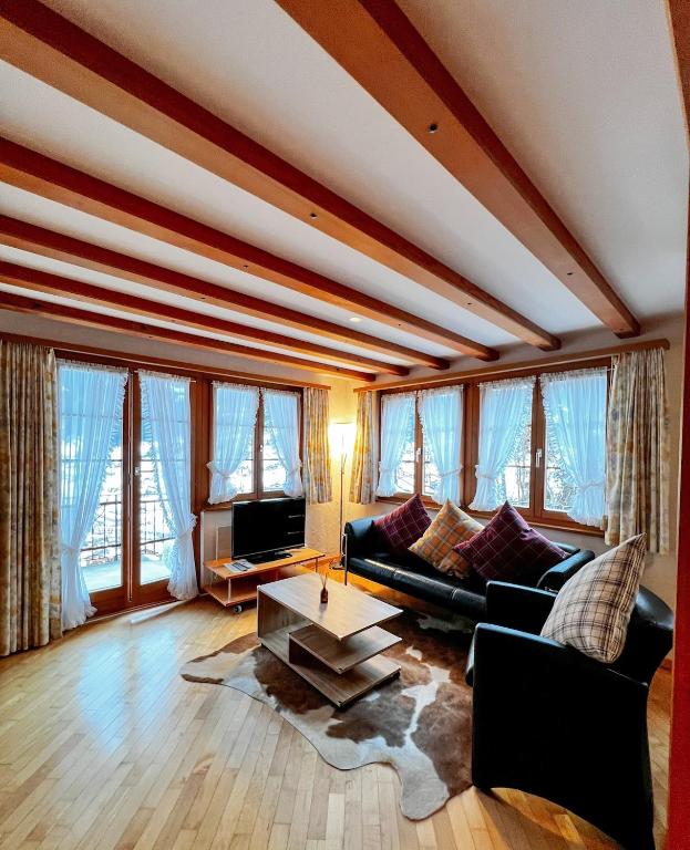 a living room with a couch and a table at Apartment Aphrodite West magnificent Eiger view in Grindelwald