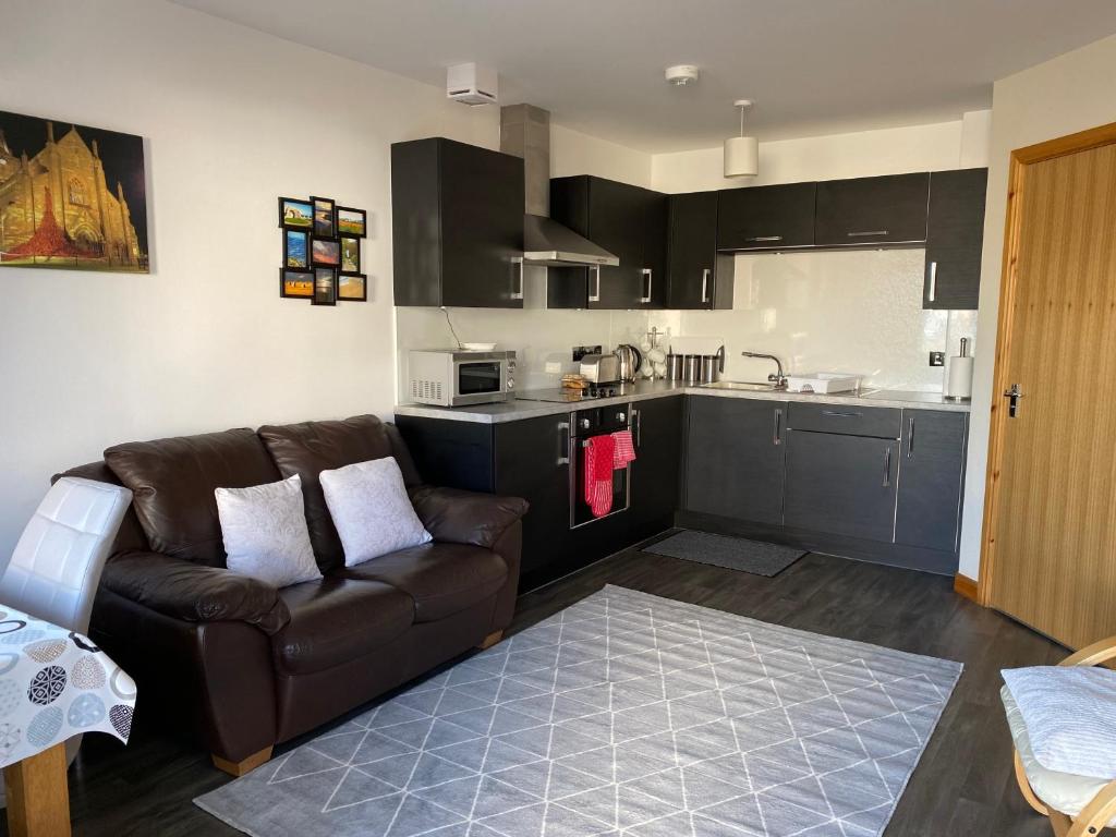 Una sala de estar con un sofá y una cocina. en Kirkwall Studios - Studio 29A, en Kirkwall