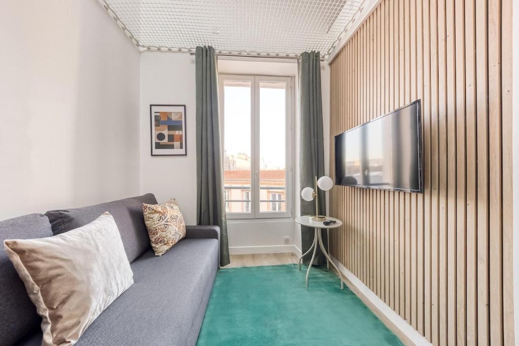 un salon avec un canapé et une télévision à écran plat dans l'établissement Sous les étoiles a Montreuil, à Montreuil