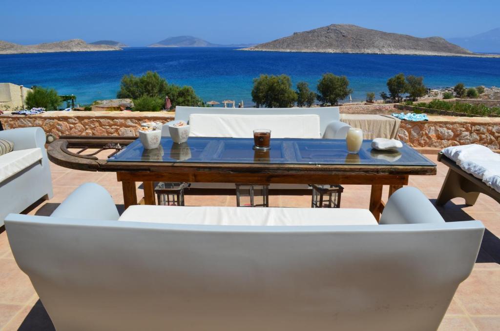 a table and chairs with a view of the ocean at Villa Blu Majestic beach villa in Halki