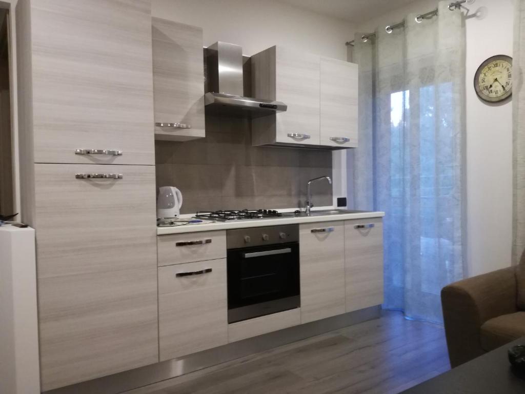 kuchnia z białymi szafkami i kuchenką w obiekcie La casa di Ale w mieście Aci Castello