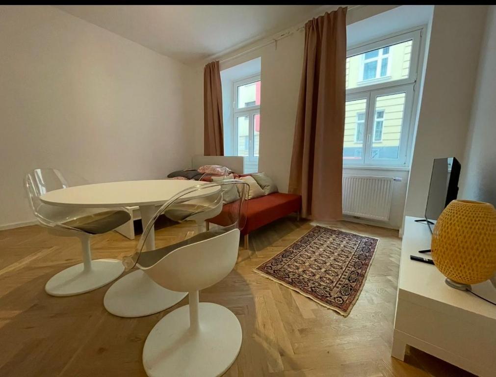 una sala de estar con una mesa, sillas y un sofá en Columbus6, en Viena