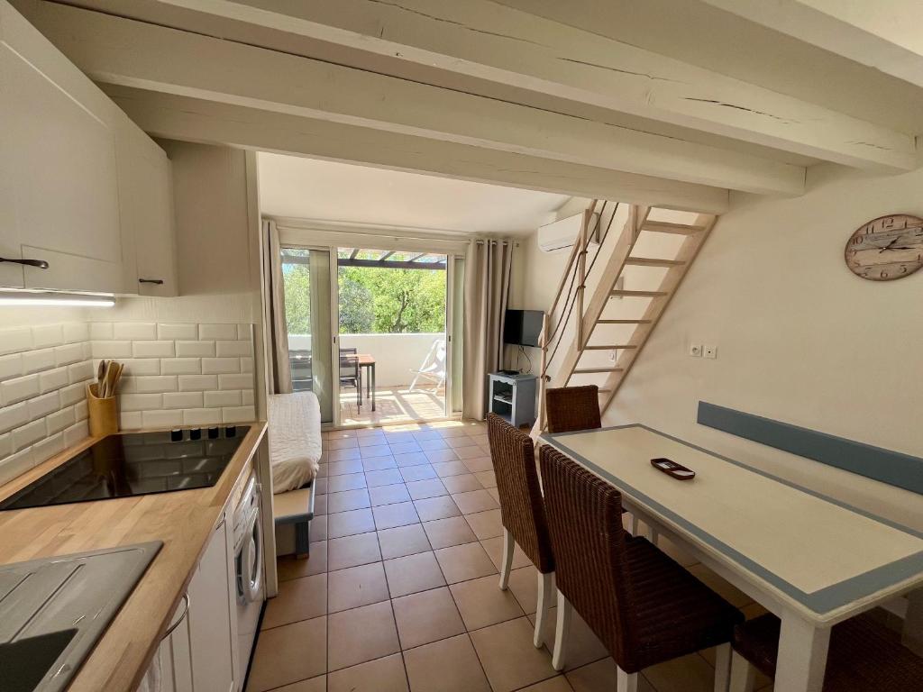 une cuisine et un salon avec un escalier et une table dans l'établissement Charmant appartement baie Saint Tropez 6 personnes, à Grimaud