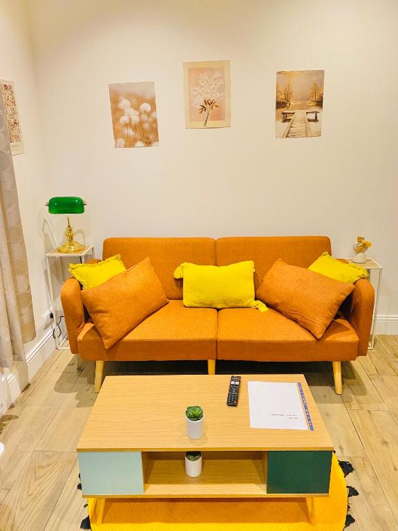 un salon avec un canapé marron avec des coussins jaunes dans l'établissement Maison de ville, à Fenouillet