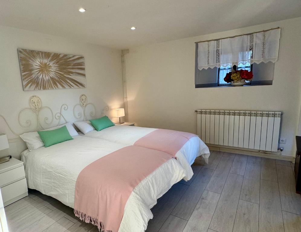 a bedroom with a large bed and a window at Casa Tía Milagros in Puebla de Sanabria