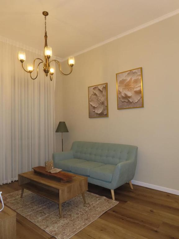 a living room with a blue couch and a coffee table at קאסה לונה בוטיק CASA LUNA boutique in Gan Yavneh
