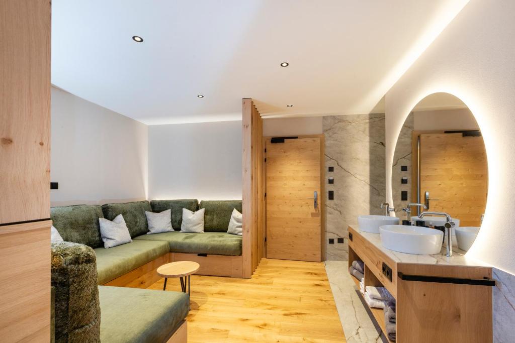 salon z kanapą i umywalką w obiekcie Hotel Lindnerhof w mieście San Lorenzo di Sebato