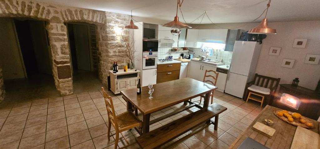 a kitchen with a wooden table and a dining room at Gîte La Grange in Saint-Laurent-dʼOlt