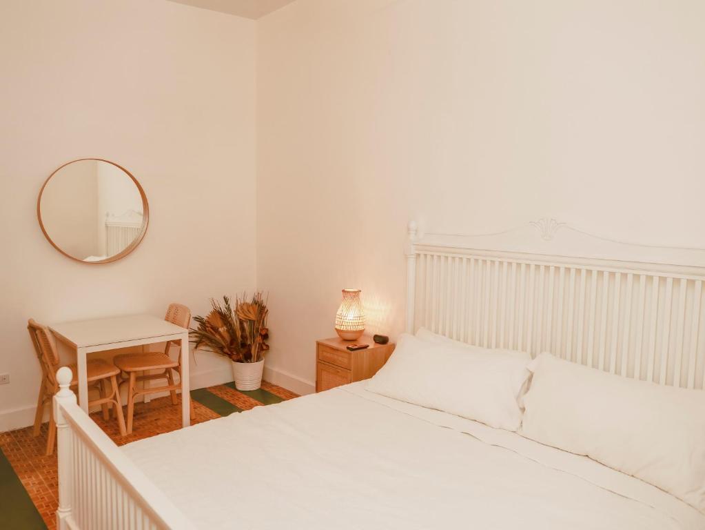 a white bedroom with a white bed and a table at Maison Rouge - Room 4 in Christiansted