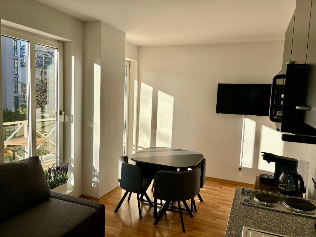 ein Wohnzimmer mit einem schwarzen Tisch und Stühlen in der Unterkunft 2-room apartment in Dresden's Neustadt in Dresden