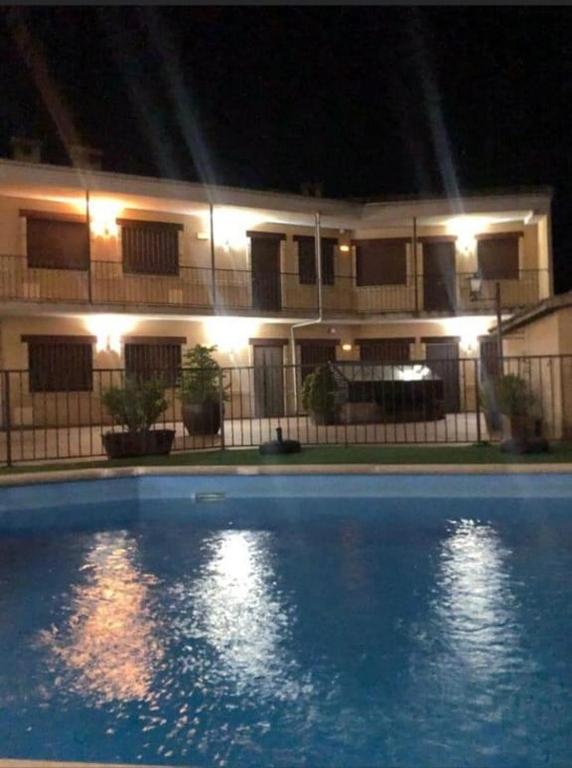 a house with a swimming pool at night at Naturaleza-confort in Arroyo Frio