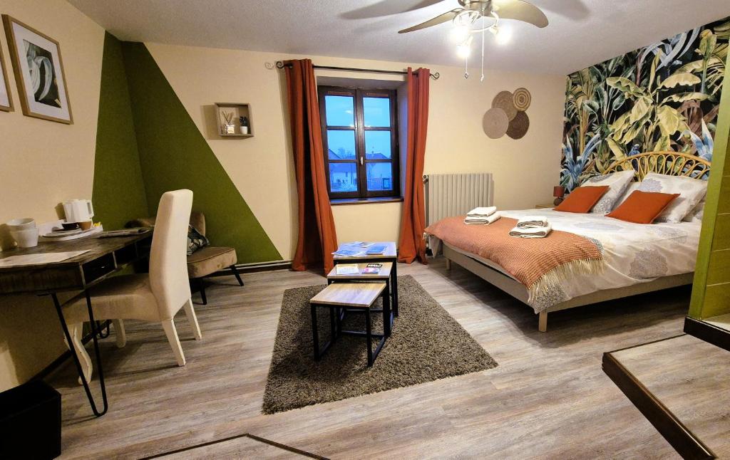 Un dormitorio con una cama, un escritorio y una mesa. en Au Lavoir du Serein "La Billaude" et "La Langouette", en Saint-Germain-lès-Arlay