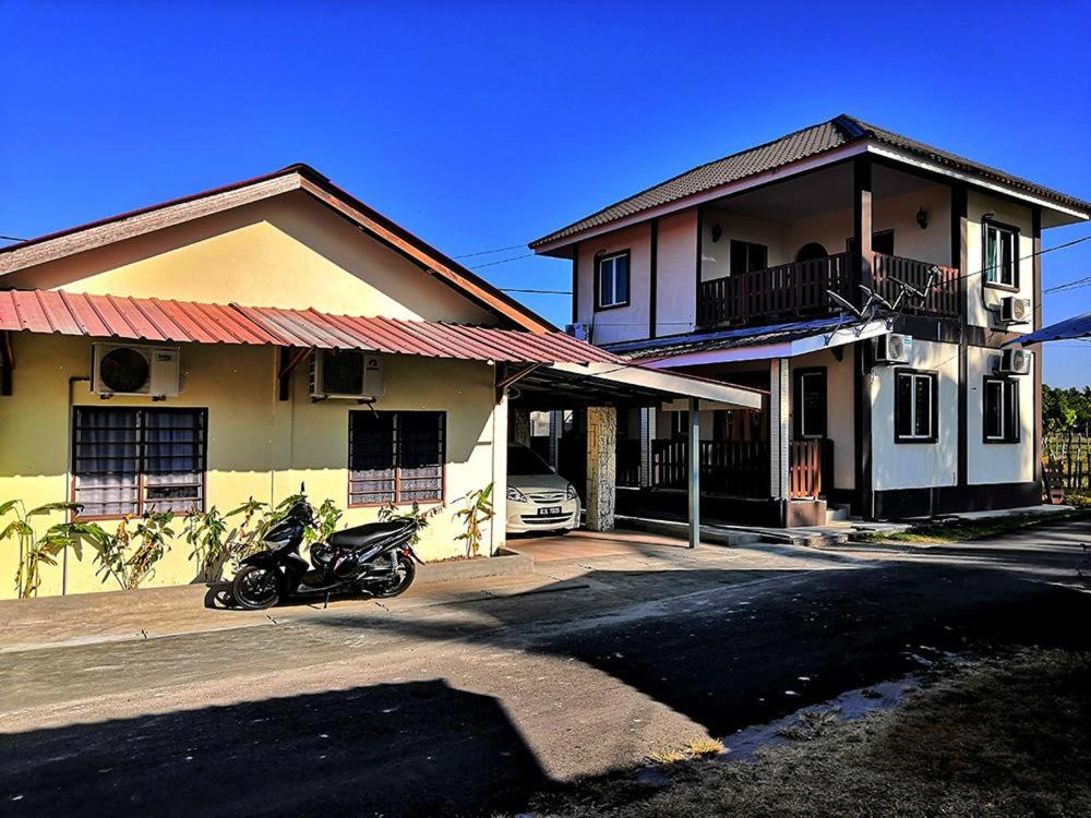 a motorcycle parked in front of a house at Super Fully Furnished House next to airport - peaceful, leisure and quite in Langkawi Intl
