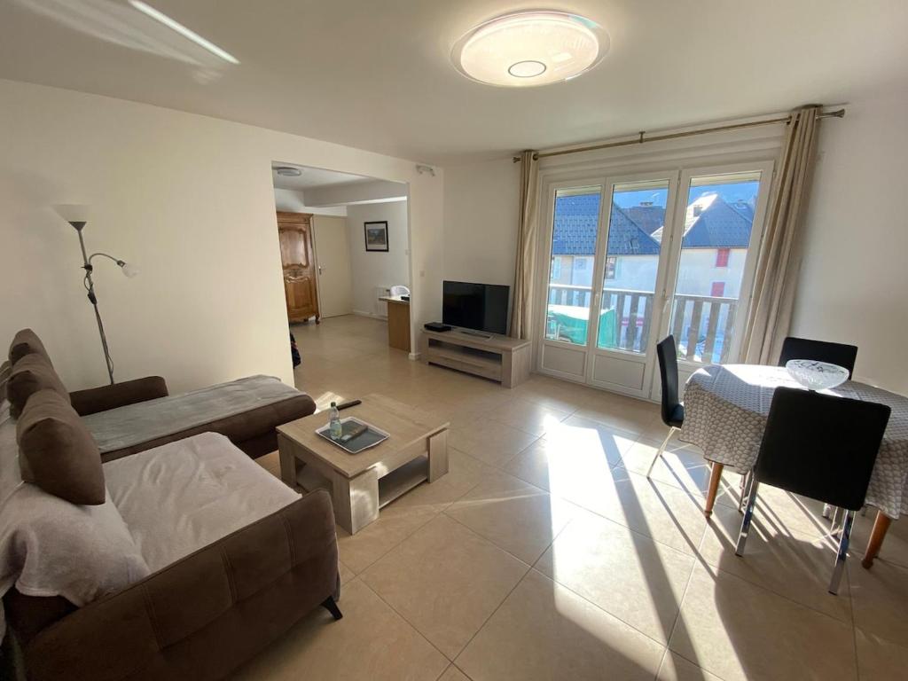 un salon avec un canapé et une table dans l'établissement Appart 4 ou 5 pers - Bike Friendly, au Bourg-dʼOisans