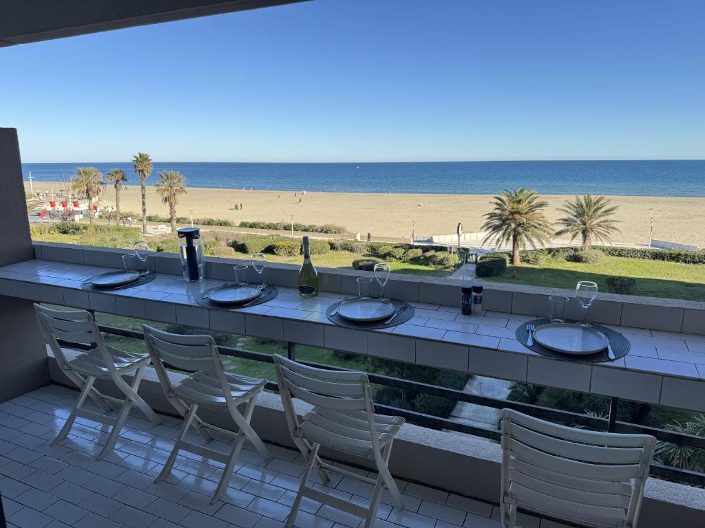 - un bar avec des chaises et une vue sur la plage dans l'établissement Le Balcon Des Vagues, à Canet