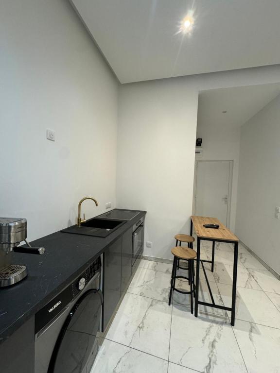 une cuisine avec un comptoir, un évier et un tabouret dans l'établissement Studio St Charles, à Marseille