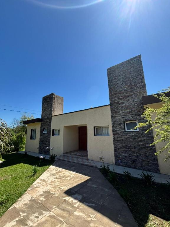 a brick house with a garage and a blue sky at Cabañas Dos Soles in Córdoba