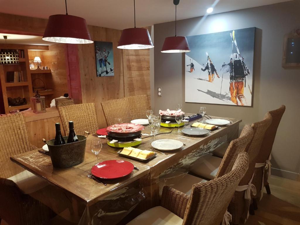 une table à manger avec des chaises et un grand tableau dans l'établissement Le Montcalm chalet Le Desman, à Ustou