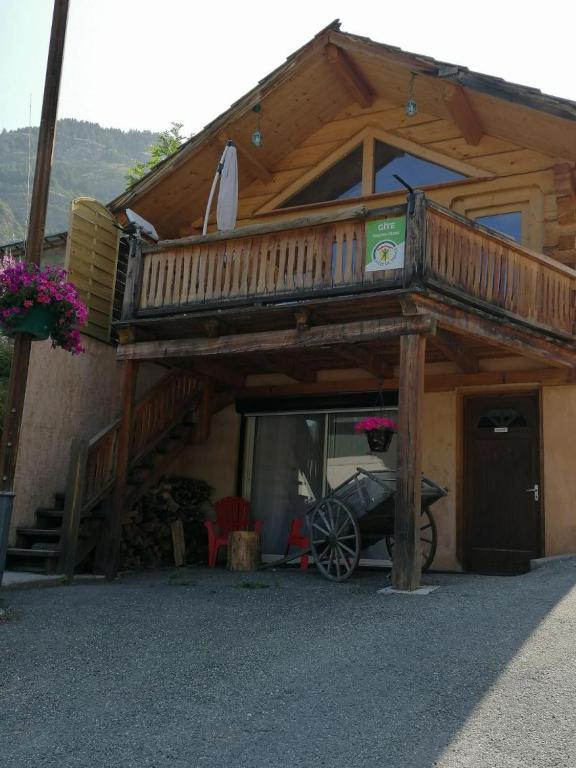 a cabin with a balcony and a car parked outside at Le Chalet d’Andrea in Vars