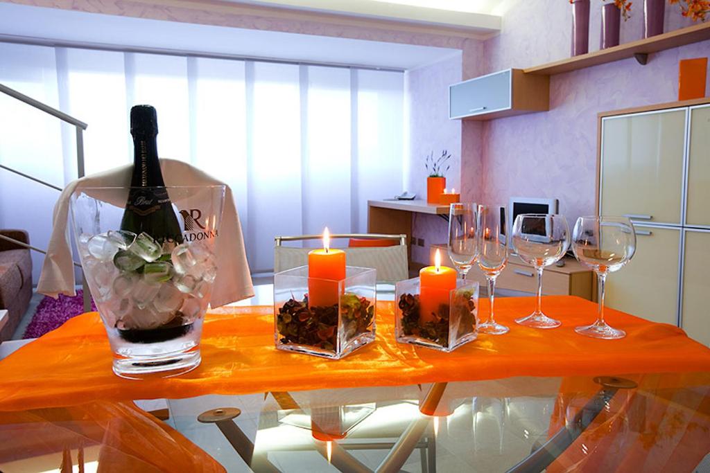 stolik z kieliszkami oraz butelkę wina i świece w obiekcie Le Onde Resort w mieście Viterbo