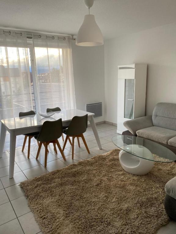 un salon avec une table, des chaises et un canapé dans l'établissement Chez Noah - 70m2 near Geneva, à Ville-la-Grand