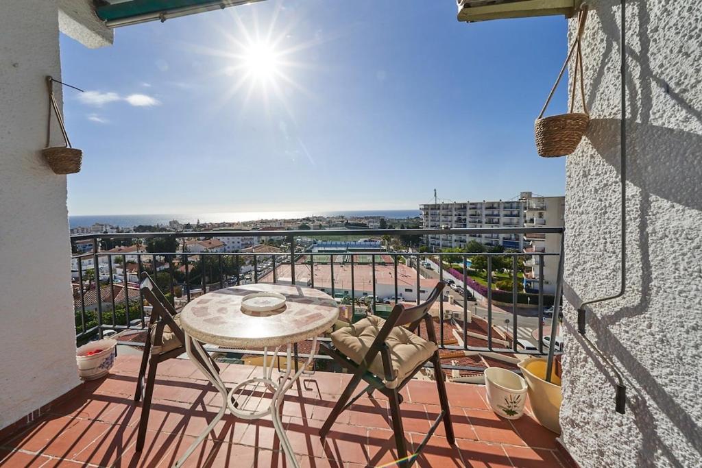 eine Terrasse mit Tisch und Stühlen auf einem Balkon in der Unterkunft Cielo Azul in Nerja