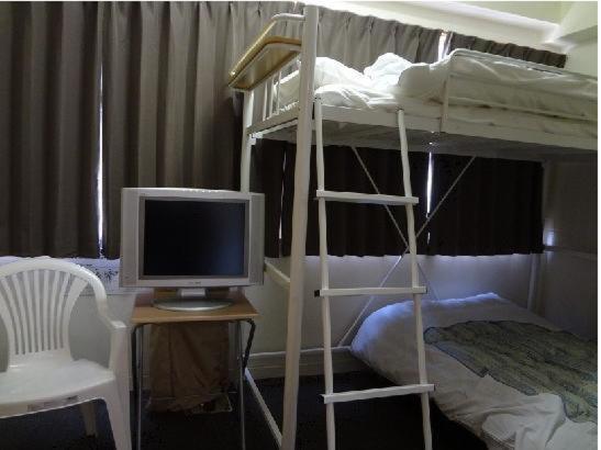 1 dormitorio con literas y escritorio con ordenador en Eco Hotel Nagoya, en Nagoya