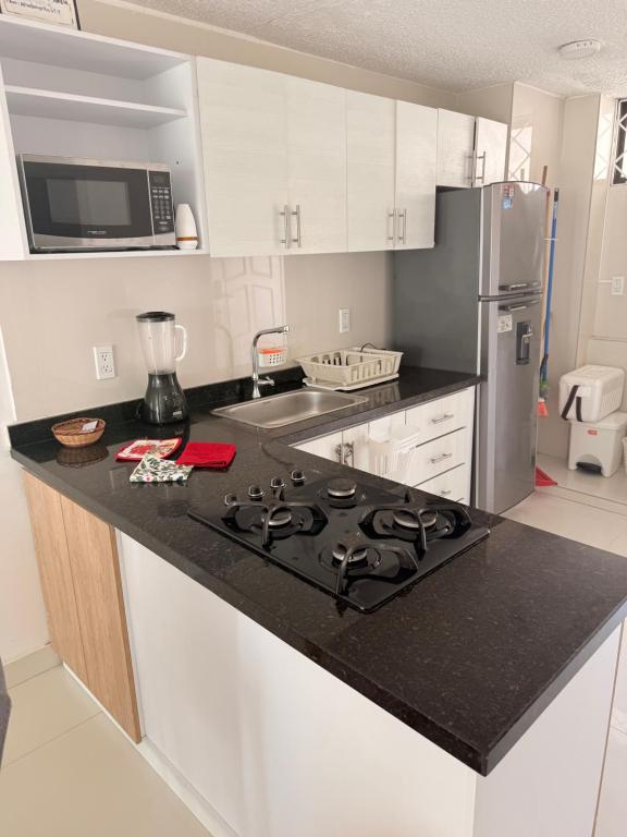 a kitchen with a black counter top with a stove at Internacional Hermoso y Céntrico in Santa Marta