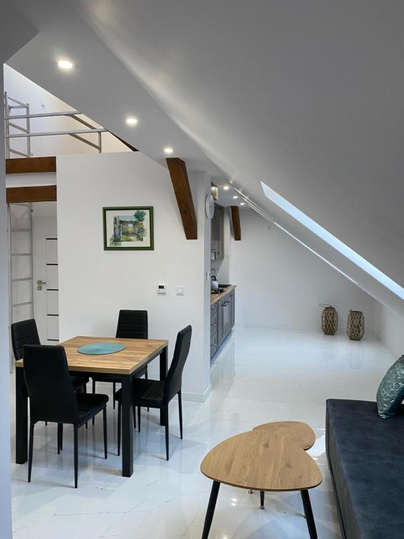 a dining room and kitchen with a table and chairs at Apartament Woda i Zieleń in Borne Sulinowo