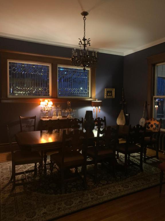 a dining room with a table and chairs and a chandelier at Lion's Head B&B in Niagara Falls