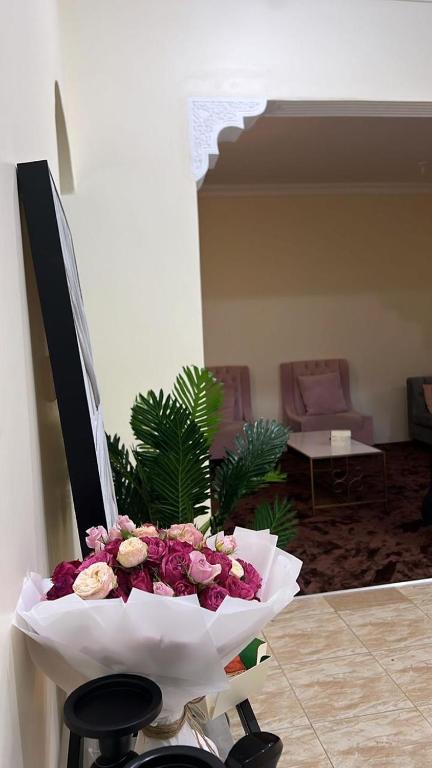 a bouquet of flowers sitting on a chair in a room at شقة فندقية الشفاء مودرن in Hail