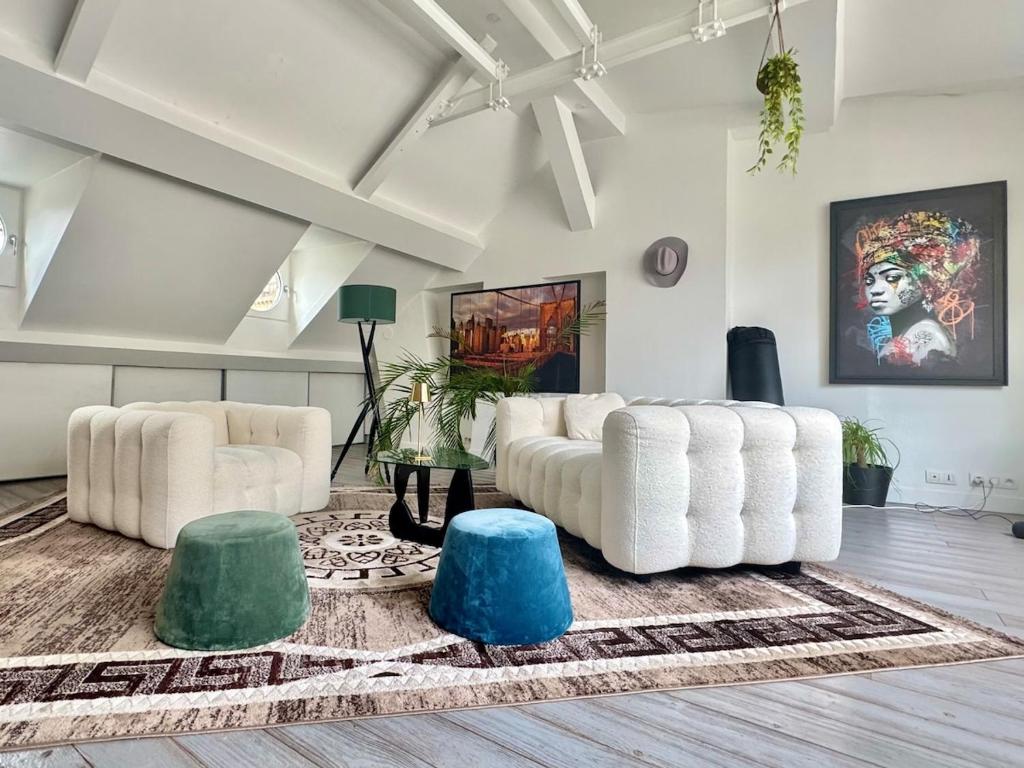 - un salon avec deux canapés blancs et un tapis dans l'établissement Charmant Parisien, à Paris