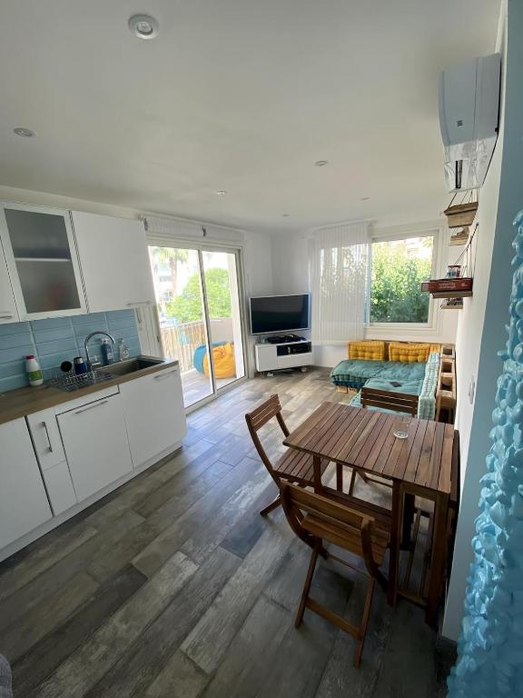 une cuisine et un salon avec une table et un canapé dans l'établissement Appt Fréjus 4 personnes plage à 100m, à Fréjus