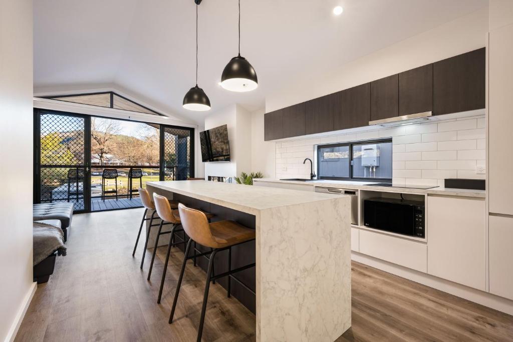 a kitchen with a large island with bar stools at Bright Riverside Holiday Park in Bright