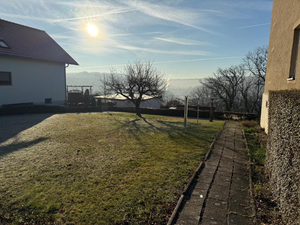 a grassy yard next to a building with the sun in the sky at Cozy Pet-Friendly Apartment in Meißen