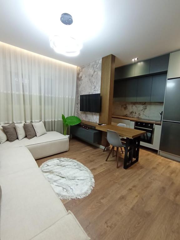 Una sala de estar con un sofá blanco y una mesa. en Ea's Luxury Apartments Korca, en Korçë