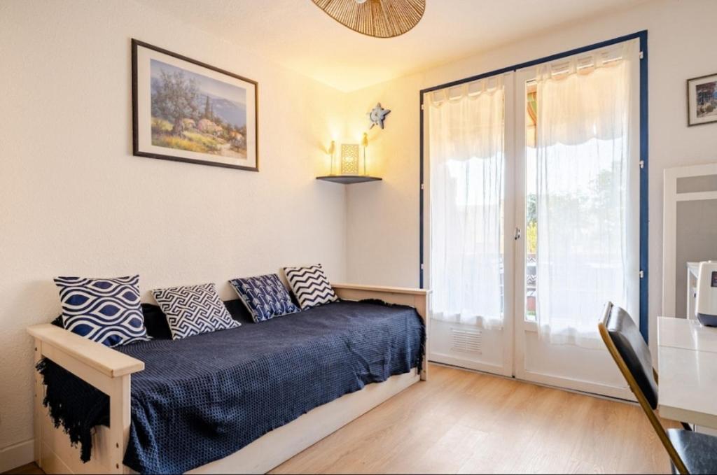 - une chambre avec un canapé et une grande porte coulissante en verre dans l'établissement Appartement 