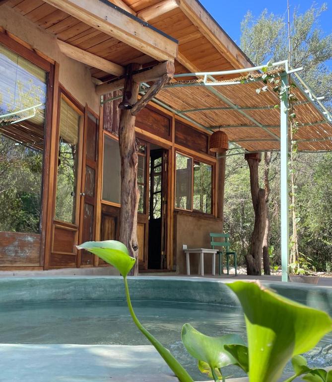 a house with a swimming pool with a wooden roof at Casa LaMora in San Marcos Sierras