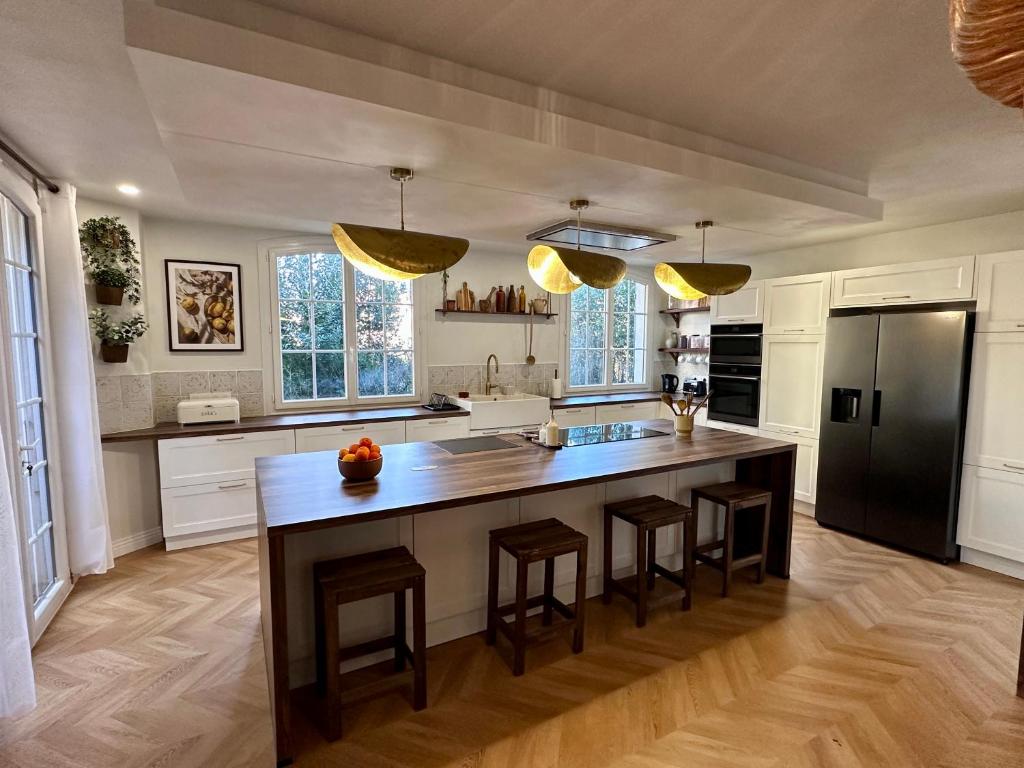 - une cuisine avec un grand îlot de cuisine avec des tabourets de bar dans l'établissement Villa Mimpi - Castres, France, à Castres