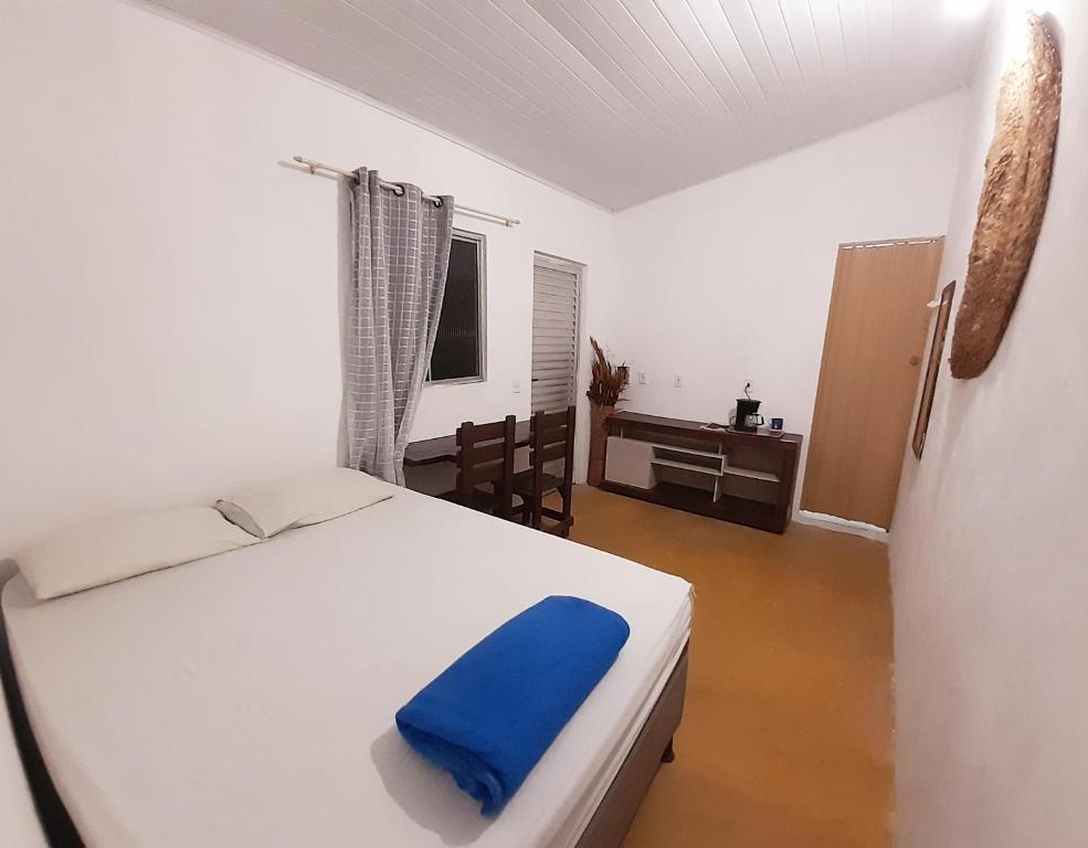 een slaapkamer met een bed met een blauw kussen erop bij Casinha Guiné in Morro de São Paulo