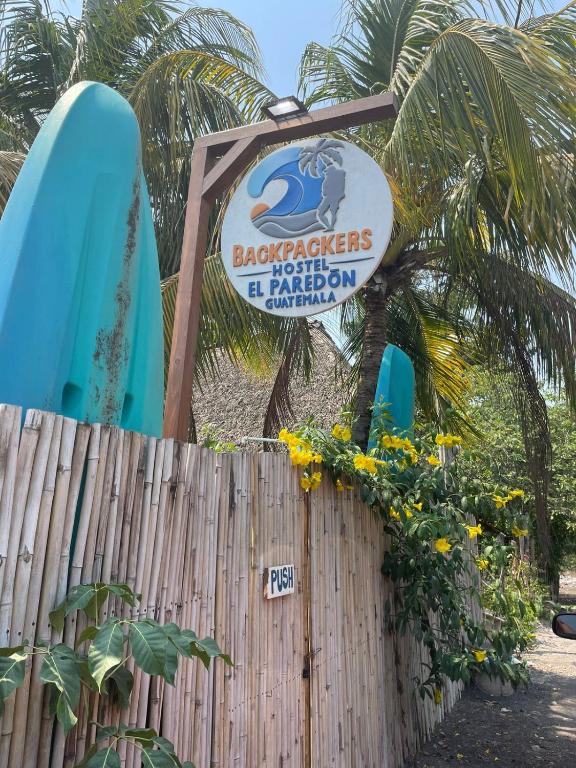 un cartel para un complejo de playa con tabla de surf en Backpackers Hostel, en El Paredón Buena Vista