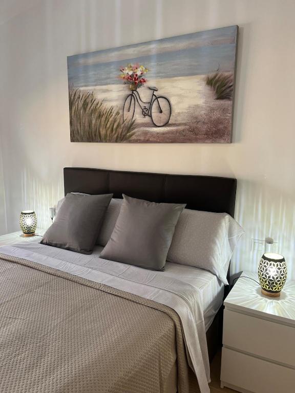 a bedroom with a bed with a painting on the wall at Casa Yanelis in Antigua