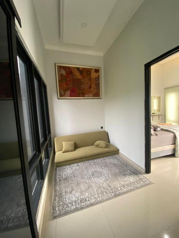 a couch sitting in a room with a mirror at Villa Kenangan in Tlekung